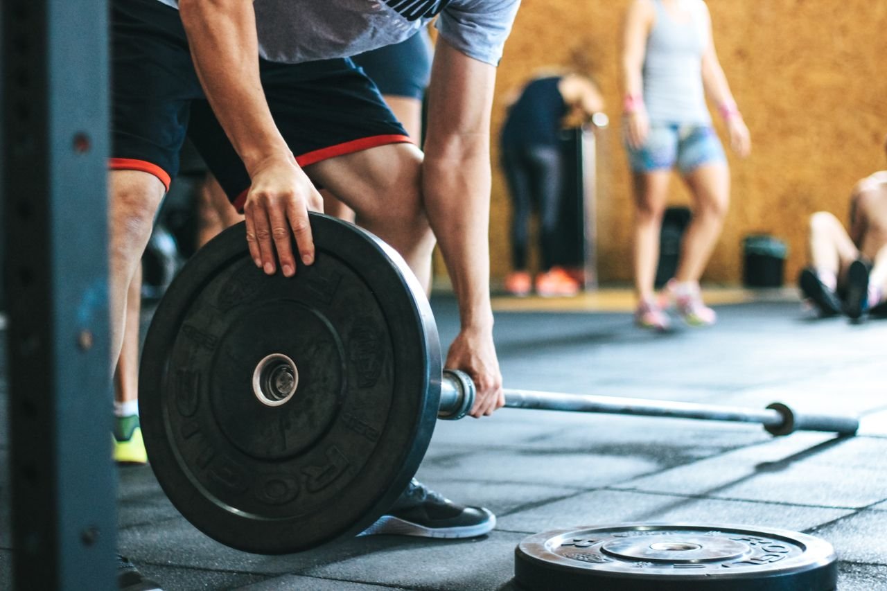 heros-img Focused weightlifting session in a gym with diverse athletes participating indoors.